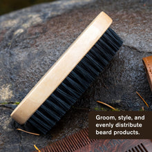 Men's beard brush close-up with light wooden handle and dark bristles