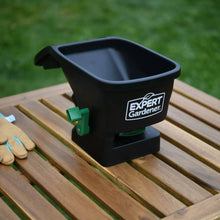Handheld broadcast spreader on wooden boards with green side lever