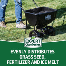 Black push broadcast spreader with hopper and wheels for spreading lawn materials