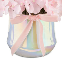 Iridescent pot with pale pink ribbon and bow beneath pink hydrangea blossoms