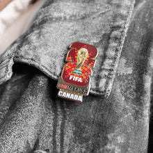 Enamel lapel pin featuring FIFA logo with Canada label on gray fabric