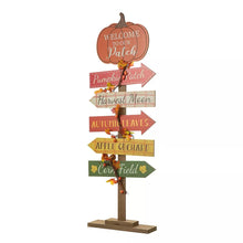 Freestanding wooden pumpkin patch sign with stacked arrow plaques reading Welcome to our Patch