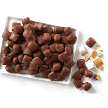 Chocolate-coated pieces and marshmallows in a tray, with some crumbs nearby