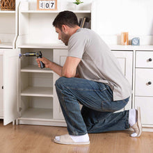 Electric screwdriver fastening a cabinet screw inside a white cabinet