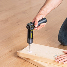 Electric screwdriver driving a screw into a wooden board