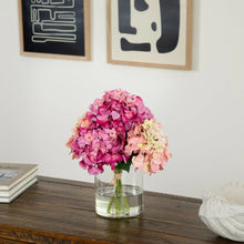 Faux hydrangea arrangement in clear vase with pink, fuchsia, and pale peach blooms