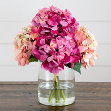 Pink and magenta faux hydrangea arrangement with pale peach blossoms in clear vase
