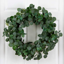 Faux eucalyptus wreath with dense dark green oval leaves in a round shape.