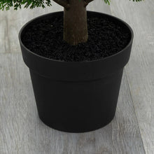 Black planter pot with faux cedar tree trunk and dark potting soil