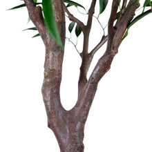 Faux willow tree trunk close-up with textured brown branches and green leaves