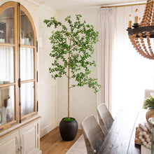 Artificial faux quince tree with green leafy branches in a dark pot