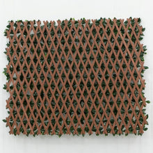 Expandable faux gardenia trellis folded flat, showing its brown lattice backing and green leaves
