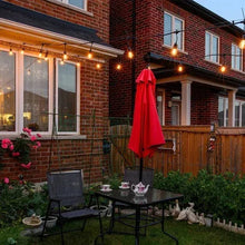 LED string lights with dark cord and glowing bulbs along brick house