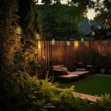 Outdoor cafe string lights with warm clear bulbs strung along a black line