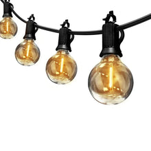 Cafe string lights close-up: black sockets with clear round bulbs on black cord
