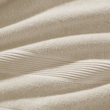 Cream terry towel texture close-up with looped fabric and ribbed border detail