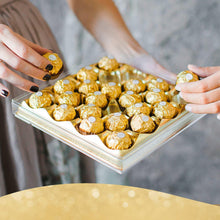 Milk chocolate hazelnut candies in clear tray, gold foil wrappers with white tops