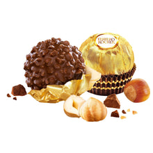 Milk chocolate hazelnut candies with gold foil wrappers, chocolate pieces and hazelnuts