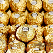 Gold-wrapped Ferrero Rocher milk chocolate hazelnut candies, close-up pile