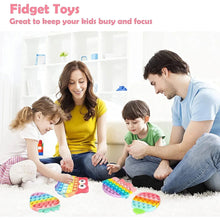 Colorful pop it fidget toys with round and heart shapes on a blanket