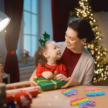 Desk pop it fidget toys with colorful bubble lids beside wrapped gift