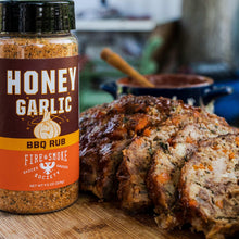 Honey garlic BBQ rub bottle next to sliced grilled meat coated with seasoning