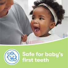 Baby with First Firefly light-up training toothbrush for first teeth.