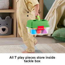 Kid holding a green Fisher-Price tackle box with shape blocks