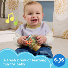 Learning coffee mug toy with camo print and ABC/123 buttons held by a smiling baby