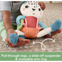Snow leopard sensory plush with orange romper and teal arms, held by child