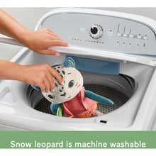 Snow leopard plush in washing machine drum, held open by a hand