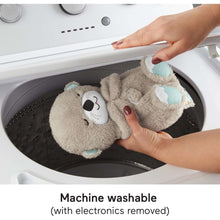 Plush otter baby sound machine lying in a washing machine drum