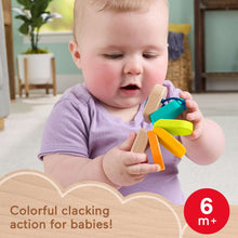 Wooden clacker caterpillar rattle in toddler hands with teal, green, and orange pieces