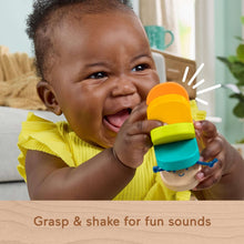 Wooden clacker caterpillar rattle in infant hands with orange and teal segments