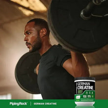 German creatine supplement tub in foreground with black lid and green label