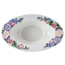 White ceramic centerpiece bowl viewed from above, with floral rim around oval well