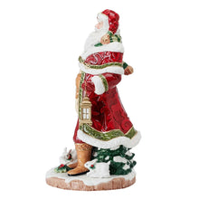 Side view Santa figurine in red and gold robe, holding a lantern