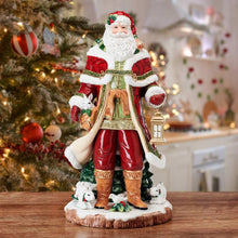 Santa figurine in red and gold outfit holding a lantern and sack