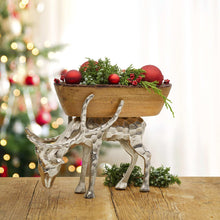 Wood centerpiece bowl on reindeer metal base with red ornaments and pine greenery
