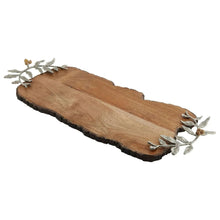 Wood serving board with dark bark rim and metal leaf and berry accents on corners