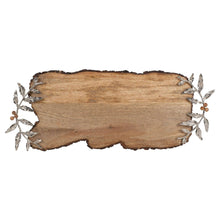 Wood serving board with bark-style edges and metal leaf and berry accents at corners