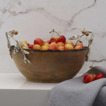 Wooden serving bowl filled with mixed fruit and silver leaf handles