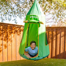 Child sitting in a green tented saucer swing with orange trim outdoors.