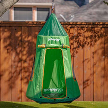Green tent swing with mesh window panels and orange trim hanging outdoors from a rope.