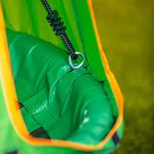 Close-up of green swing seat and tent fabric with black straps and orange trim.