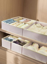 Foldable drawer closet organizer with compartment trays on dresser, light beige