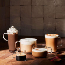 Assorted coffee drinks in glass mugs with frothy tops