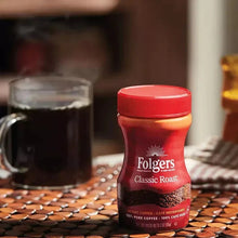 Instant coffee bottle with red lid and cup of coffee in view