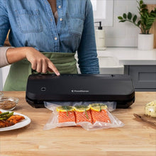 FoodSaver vacuum sealer on countertop sealing a bag with food inside
