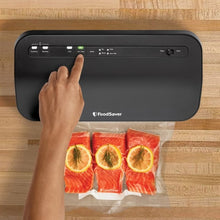 FoodSaver vacuum sealer with control panel and vacuum-sealed bags of food